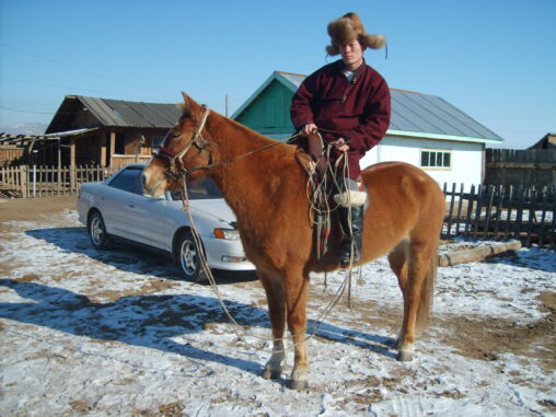 Mongolian man riding a horse