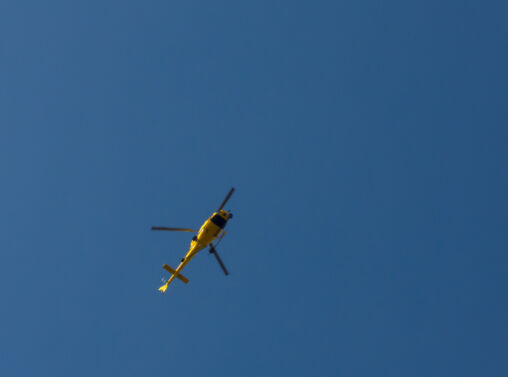 Yellow helicopter against the blue sky