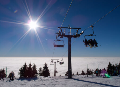 A chair lift at the top of a mountain on a sunny day