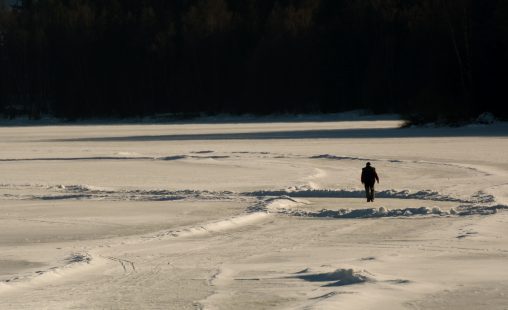 Lonely Man Walks Away on Frozen Lake